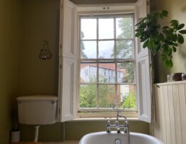 Bespoke timber window shutters in bathroom Lincoln listed property open panels