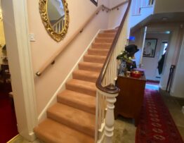 Hardwood handrail with aged brass brackets fitted to winding staircase in Lincoln